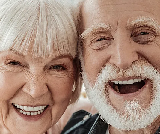 Elderly couple smiling showing off dentures