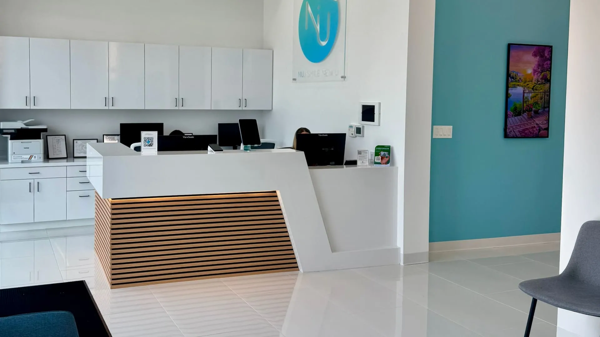 NuDentistry reception desk with modern white and wood slat design