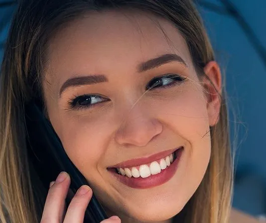 Professional whitening patient smiling under an umbrella