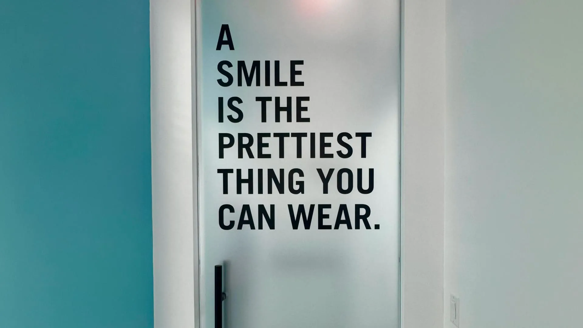Frosted glass door with smile quote at NuDentistry
